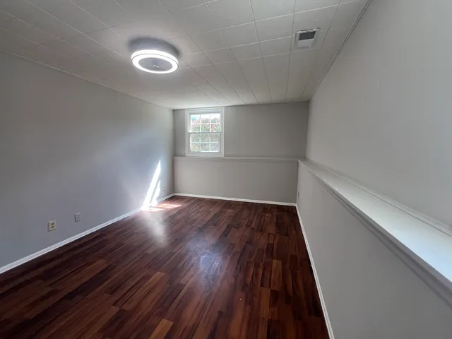 a view of empty room with wooden floor