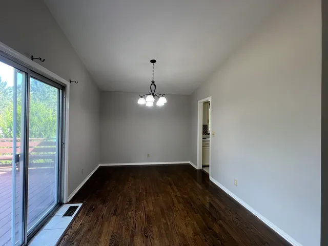 a view of a room with wooden floor large window and staircase