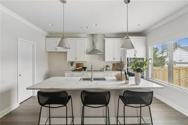 a kitchen with granite countertop a table chairs stove and cabinets