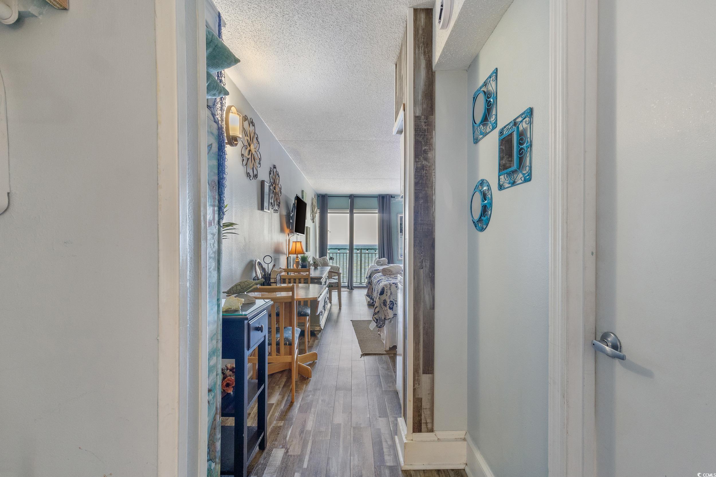 1207 South Ocean Boulevard, Unit 20603 Myrtle Beach, SC 29577 - Photo 2 of 19 Hallway featuring dark wood-style floors, a textured ceiling, and floor to ceiling windows
