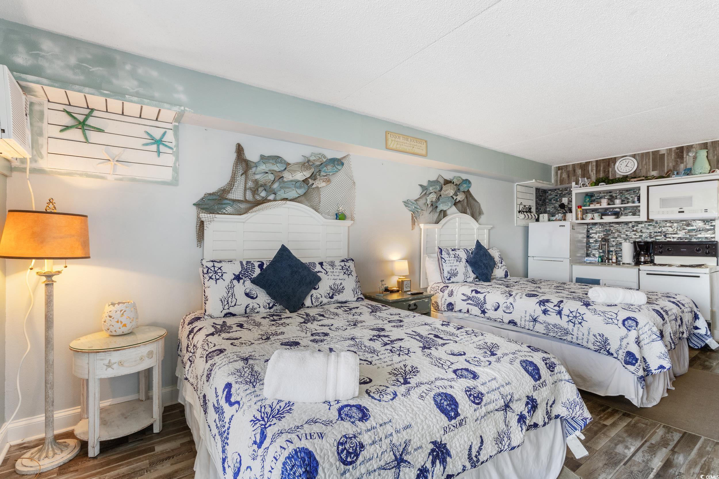 1207 South Ocean Boulevard, Unit 20603 Myrtle Beach, SC 29577 - Photo 7 of 19 Bedroom featuring dark wood-style flooring and freestanding refrigerator