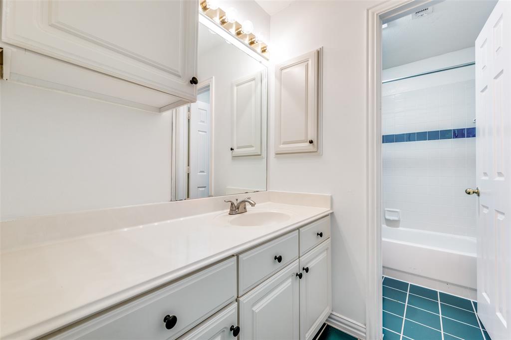 9611 Cliffside Drive Irving, TX 75063 - Photo 21 of 24 a bathroom with a sink a mirror and a bathtub