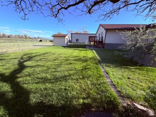 588 North 4500 West West Point, UT 84015 - Photo 53 of 61 Expansive lawn area featuring a detached storage shed and a raised wooden deck with railings