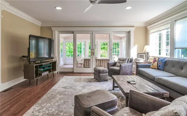 a living room with furniture a flat screen tv and a large window