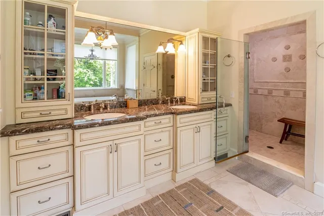 a spacious bathroom with double cabinets and a large mirror