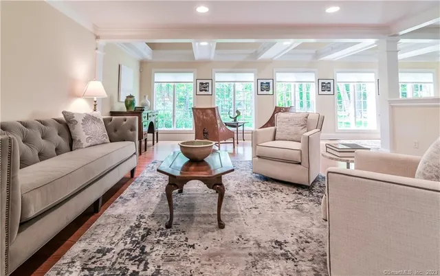 a living room with furniture wooden floor and a large window