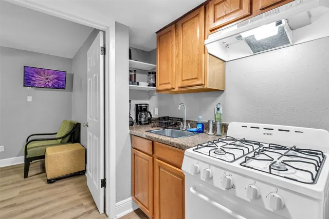 a kitchen with stainless steel appliances granite countertop a stove a sink and a refrigerator