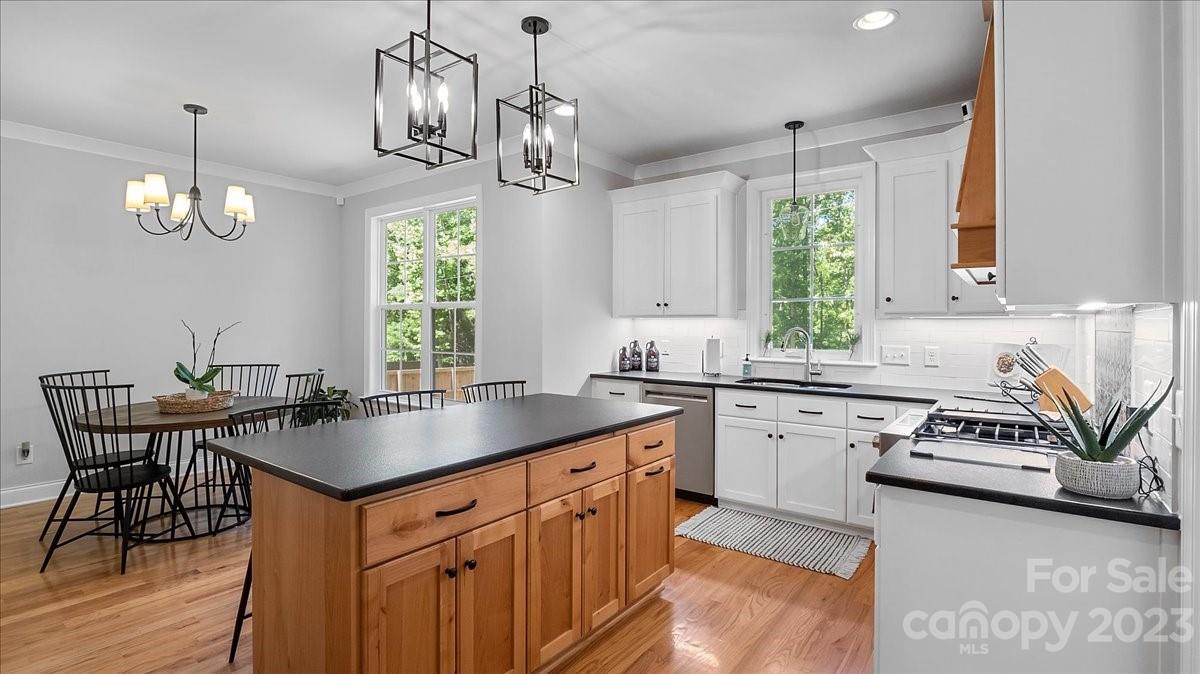 10154 Jim Sossoman Road Midland, NC 28107 - Photo 23 of 44 a kitchen with stainless steel appliances granite countertop a sink a stove a dining table and chairs
