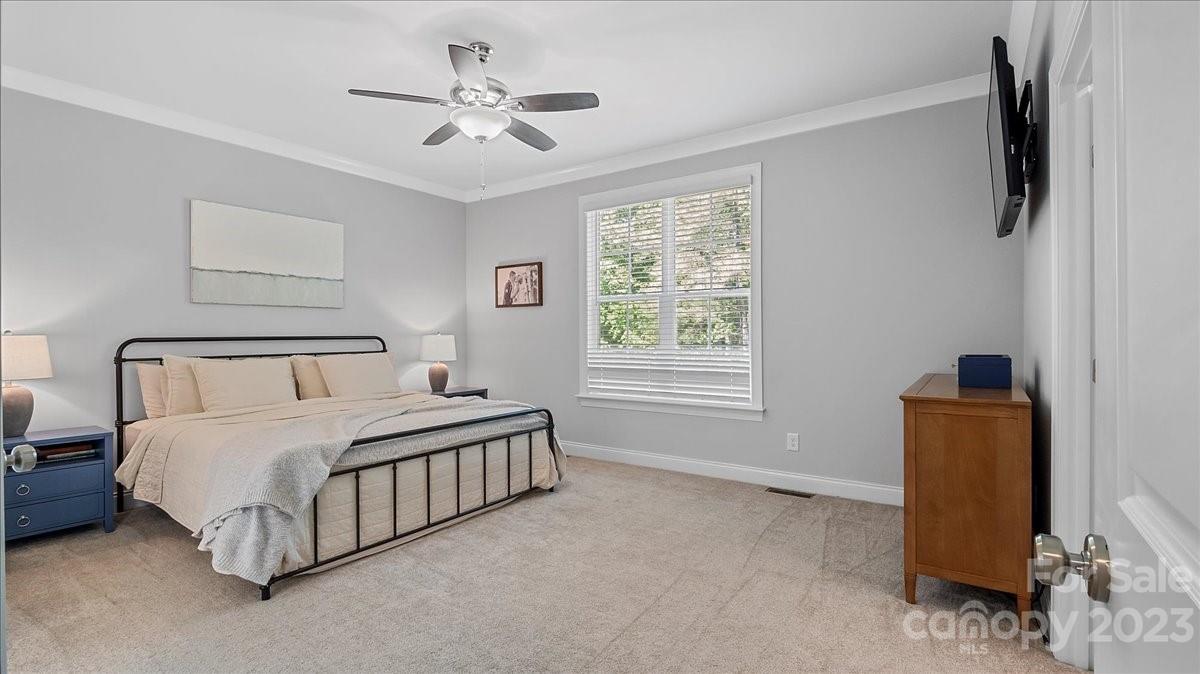 10154 Jim Sossoman Road Midland, NC 28107 - Photo 32 of 44 a bedroom with a bed chandelier and a window