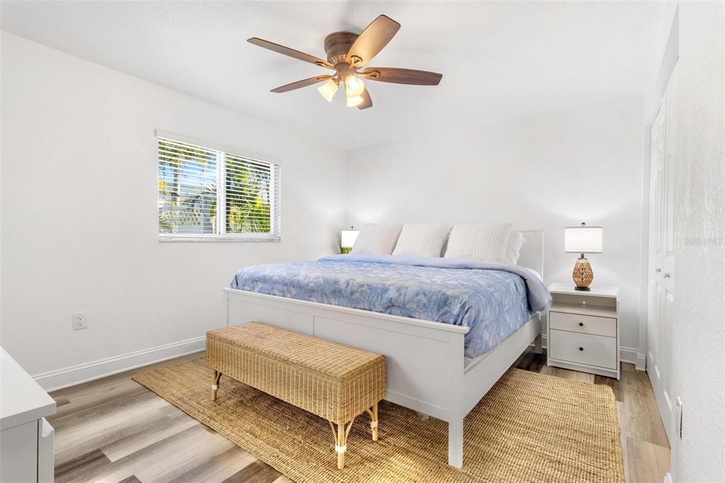 2704 2nd Street, Unit 2 Indian Rocks Beach, FL 33785 - Photo 11 of 32 a bedroom with a bed and a chandelier