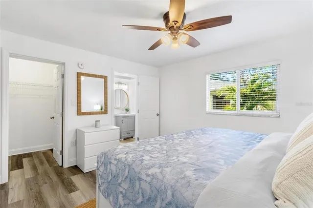 a spacious bedroom with a large bed a chandelier and windows