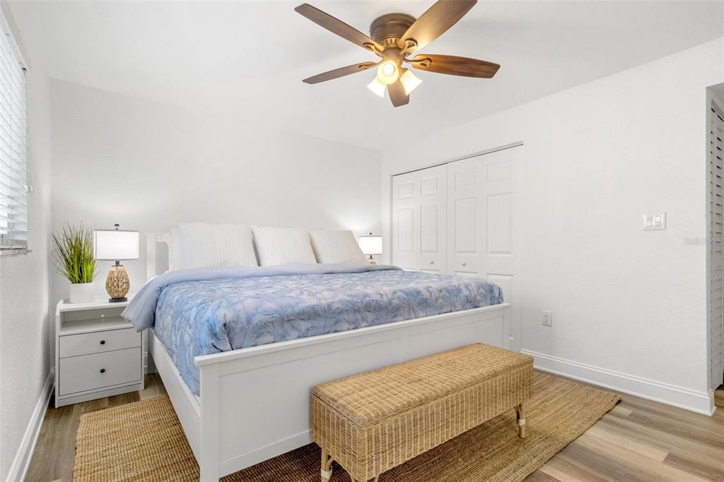 2704 2nd Street, Unit 2 Indian Rocks Beach, FL 33785 - Photo 13 of 32 a bedroom with a bed and a chandelier