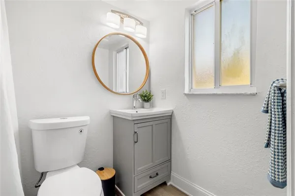 a bathroom with a toilet a sink and a mirror