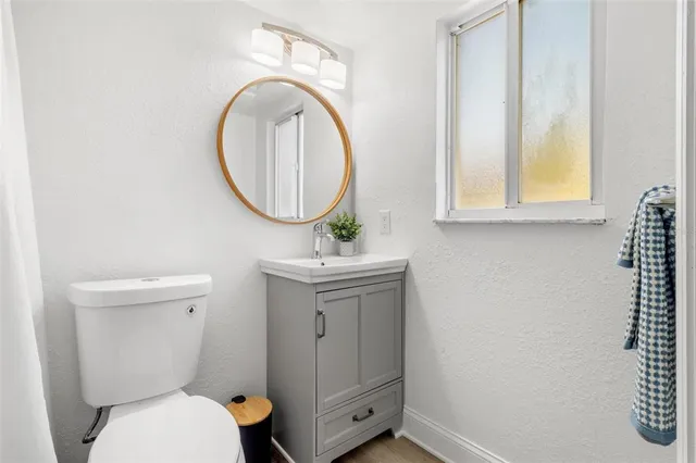 a bathroom with a toilet a sink and a mirror