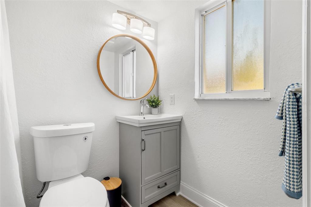 2704 2nd Street, Unit 2 Indian Rocks Beach, FL 33785 - Photo 15 of 32 a bathroom with a toilet a sink and a mirror