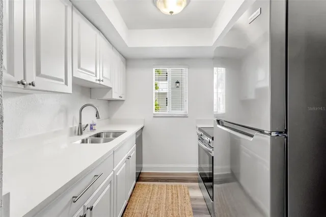 a kitchen with a sink a refrigerator and cabinets