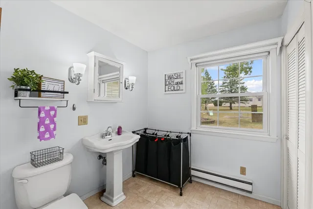 a bathroom with a sink toilet and window