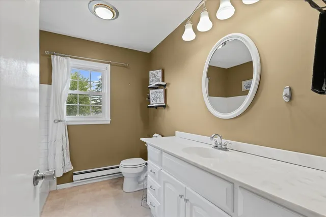 a bathroom with a toilet sink vanity and mirror