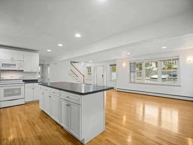 a large kitchen with granite countertop a stove a sink and a refrigerator