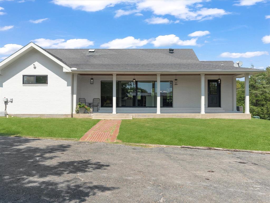 946 Burke Road Gunter, TX 75058 - Photo 25 of 38 Rear view of house featuring brick siding, roof with shingles, a lawn, and a covered porch