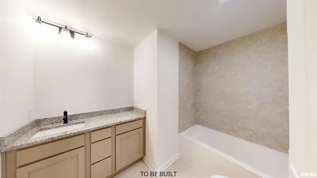 a bathroom with a granite countertop sink and a bathtub