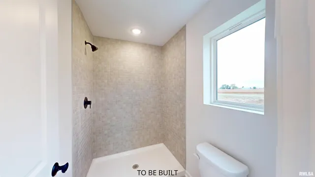 a bathroom with a toilet and a shower