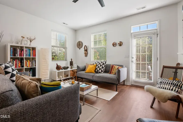 a living room with furniture kitchen view and a chandelier