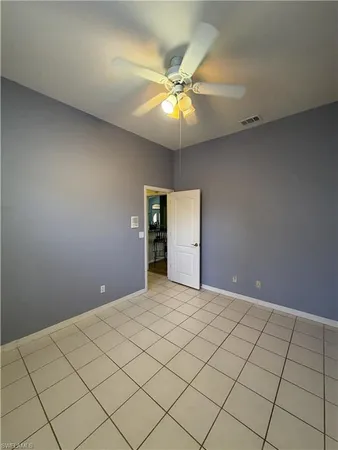 a view of an empty room and chandelier fan
