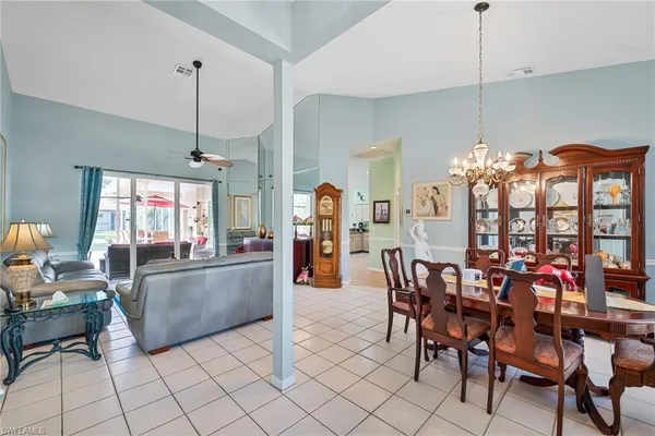 a living room with furniture a dining table and a chandelier