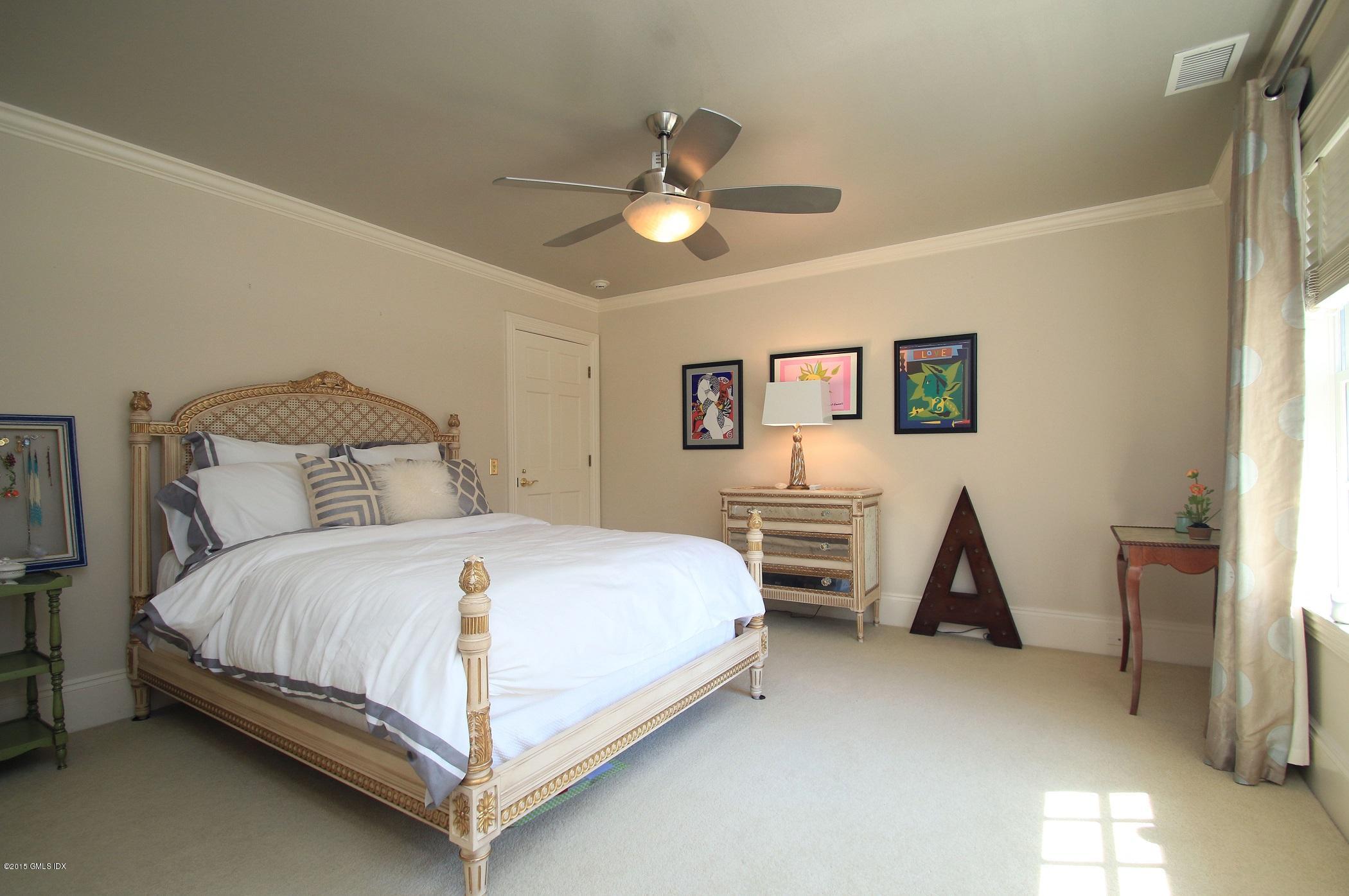 27 Chieftans Road Greenwich, CT 06831 - Photo 22 of 31 a bedroom with a bed and a chandelier