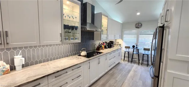 a kitchen with granite countertop a sink stove and cabinets