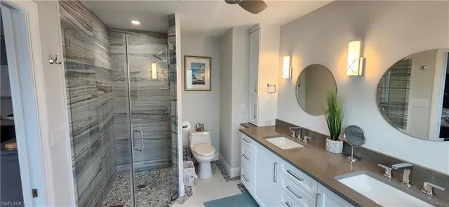a bathroom with a double vanity sink mirror and toilet