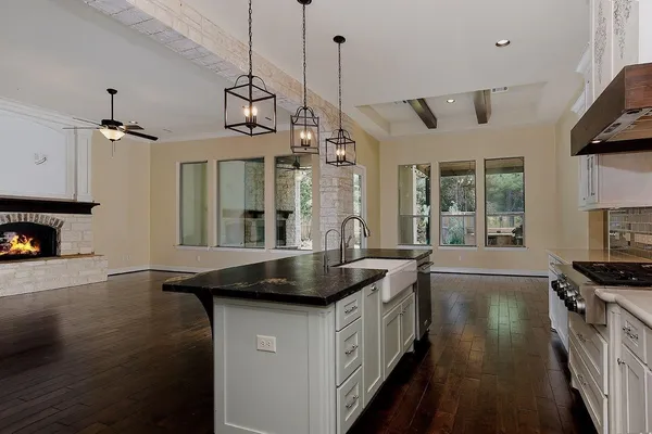 a kitchen with stainless steel appliances granite countertop a sink a stove and a wooden floors