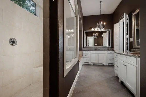 a bathroom with a double vanity sink a mirror and a bathtub
