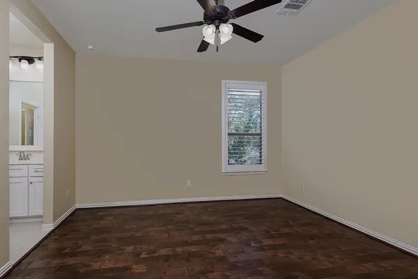 an empty room with a window and a ceiling fan