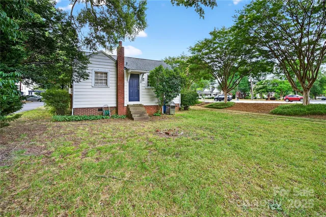 a view of backyard of house with green space