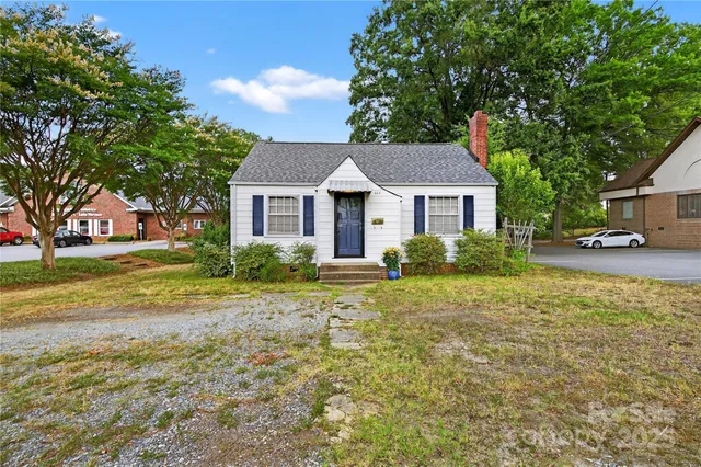 a front view of a house with a yard and trees