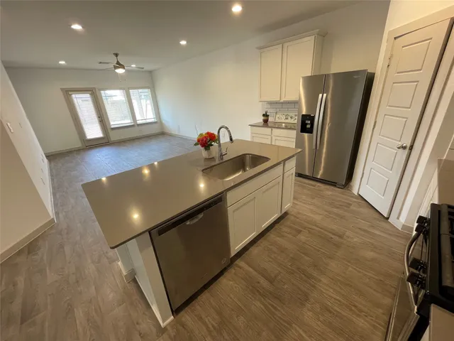 a large kitchen with stainless steel appliances granite countertop a refrigerator a sink and a stove