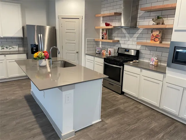 a kitchen with stainless steel appliances granite countertop a sink stove and refrigerator