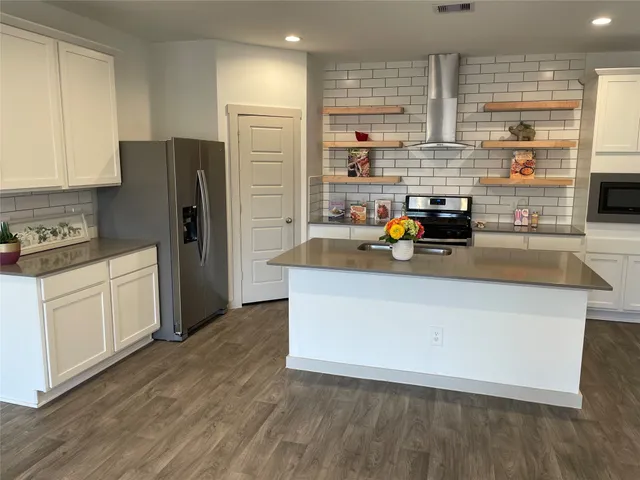 a kitchen with stainless steel appliances a refrigerator sink and cabinets