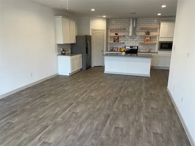 a kitchen with stainless steel appliances a refrigerator and a stove top oven