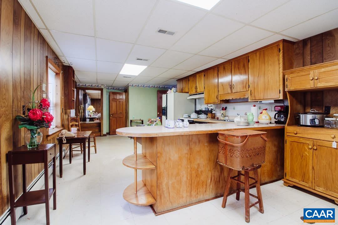 5742 Willow Spring Road Crozet, VA 22932 - Photo 30 of 34 a kitchen with stainless steel appliances granite countertop a refrigerator a sink dishwasher a dining table and chairs with wooden floor