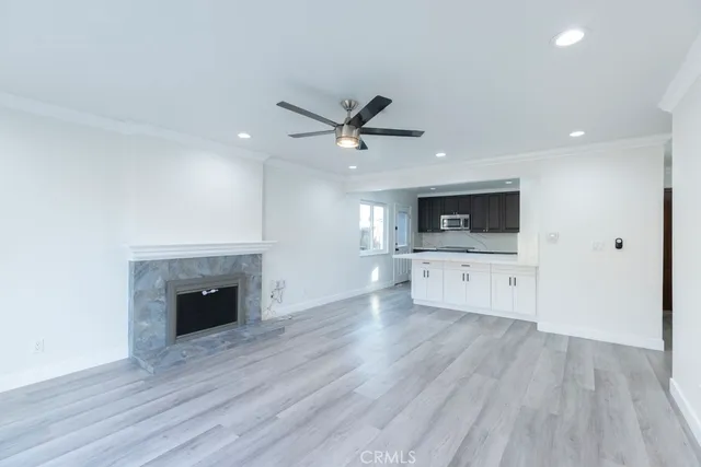 a view of an empty room with a kitchen and a fireplace