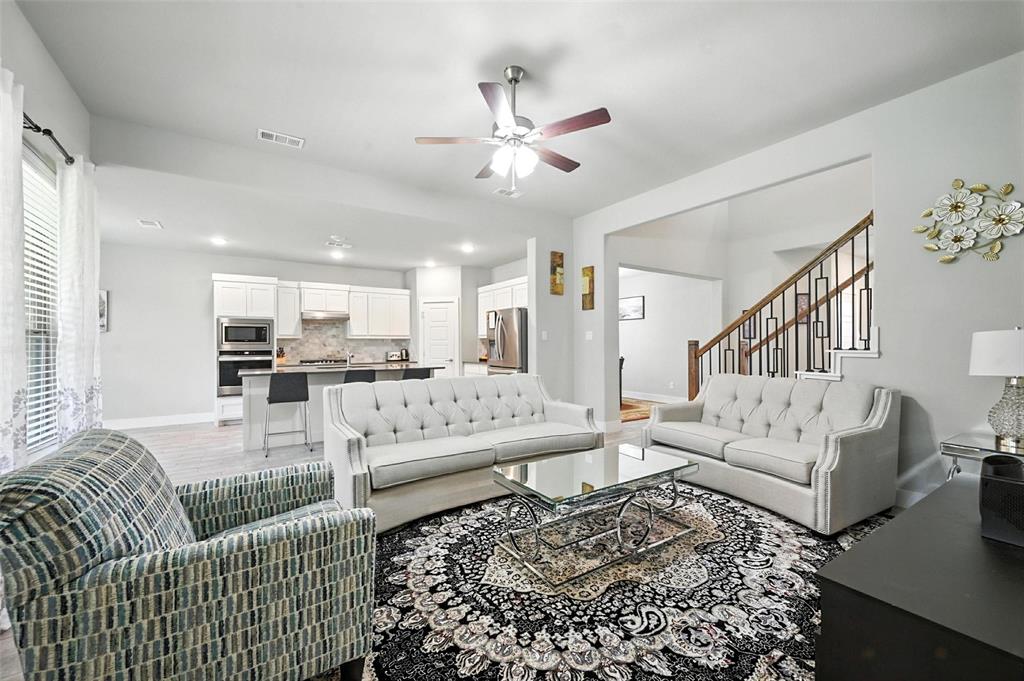 a living room with furniture and a view of kitchen