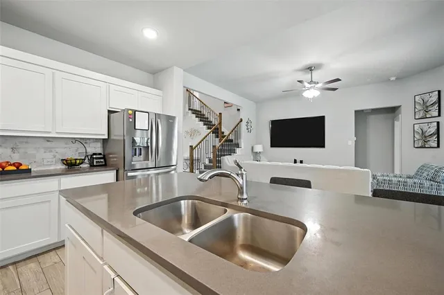 a kitchen with stainless steel appliances a sink microwave and refrigerator