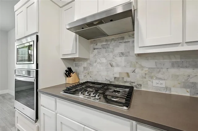 a stove top oven sitting inside of a kitchen