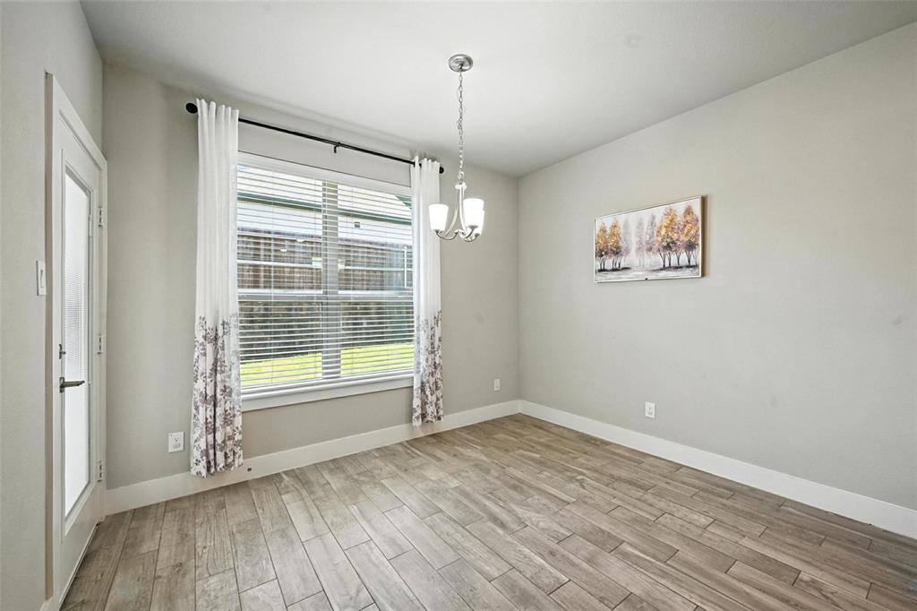 113 Nathan Drive Princeton, TX 75407 - Photo 16 of 39 a view of an empty room with a window and hardwood floor