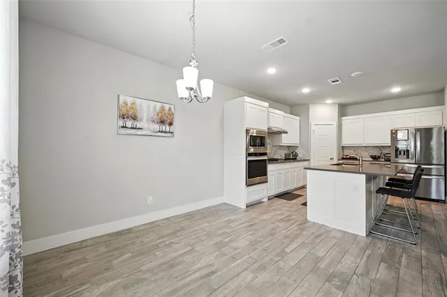 a view of kitchen with refrigerator microwave and stove
