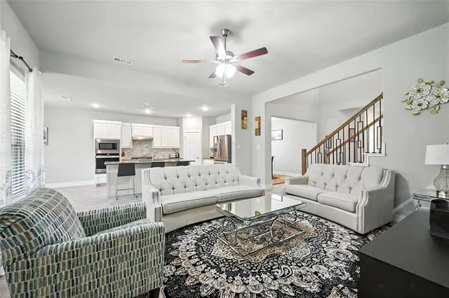 a living room with furniture and a view of kitchen