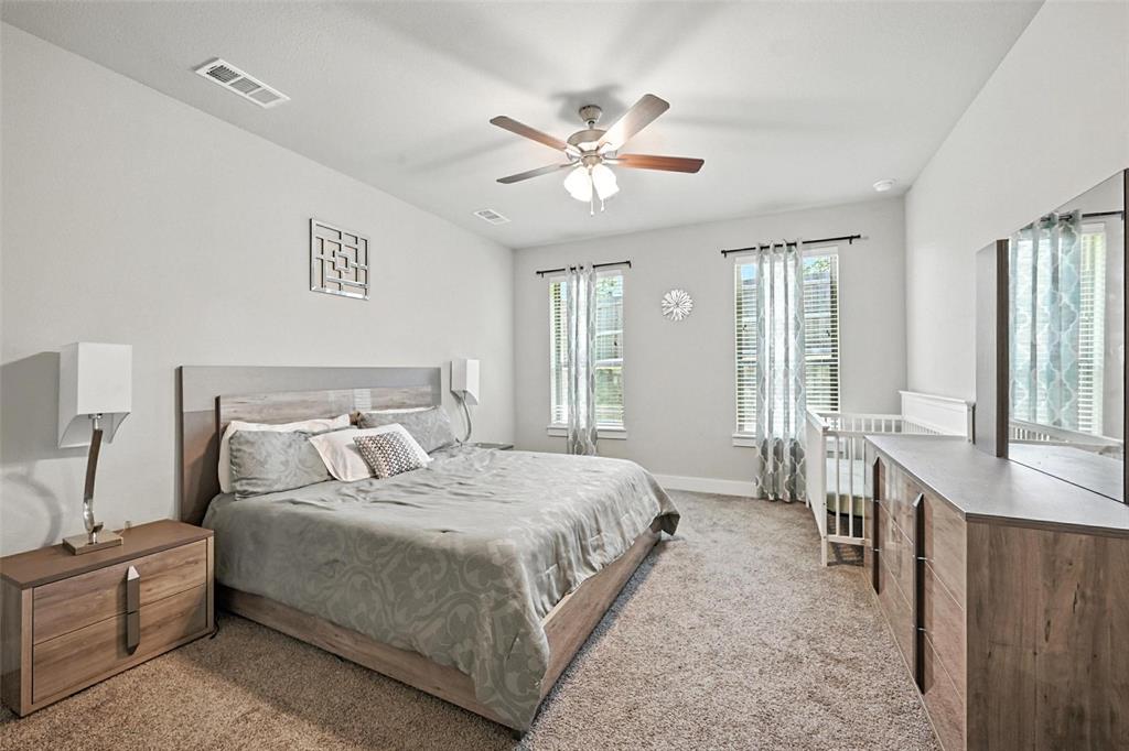 113 Nathan Drive Princeton, TX 75407 - Photo 20 of 39 a bedroom with a large bed and a chandelier